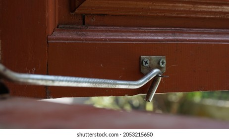 A Metal Window Hook Placed On Windowsill. A Steel Window Lock Hook Placed To Keep The Window Open