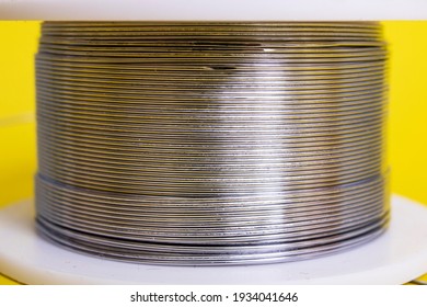 Metal Wire Spool On A Yellow Background Close Up