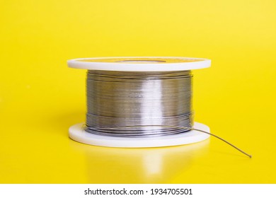 Metal Wire Spool On A Yellow Background Close Up