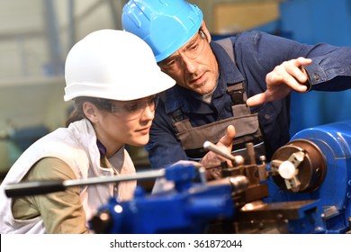 Metal Worker Teaching Trainee On Machine Use