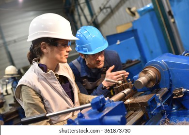 Metal Worker Teaching Trainee On Machine Use