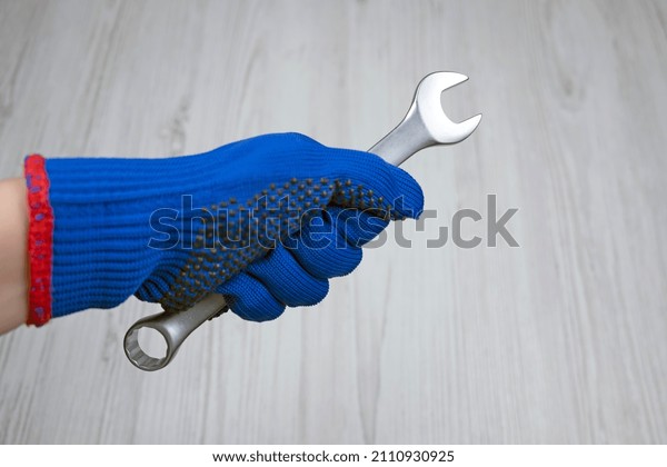 metal\
wrench in hand.  Equipment repair. Car\
service