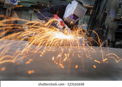 Metal wroker in a factory grinding with sparks - Powered by Shutterstock