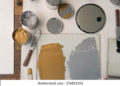 METALIC SOLVENT PAINT IN CANS AND ON KNIFE USED IN PRINTING AND LETTERPRESS WITH WOODEN TABLE AND CRAFT BACKGROUND