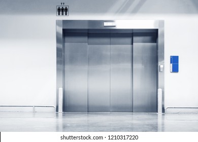 Metallic Doorway Of Modern Elevator In Office Building, Architecture Contemporary Of Door Lift And Interior Lighting Decorative. Electronic Control Panel And Flooring Symbol Signage Of Elevator