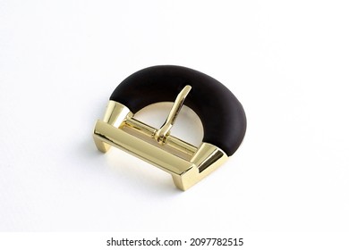 Metallic gold buckle with matte base. Buckle for a strap on a white background. Buckle for bags or clothes. Metal fittings close-up. 