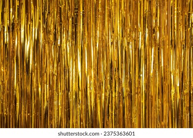 Metallic gold foil tinsel fringe decoration curtain. Birthday, wedding, Christmas, New Year party decoration background. Party decor.
