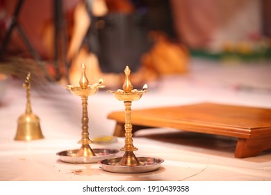 Metallic Indian Oil Lamp With Flame Placed On Floor During Pooja