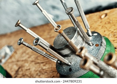 Metallic rods with varied ends rise from a circular stand, ready to manipulate delicate gears - Powered by Shutterstock