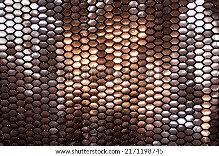 Metallic silver shinny sequin pattern texture bg with warm reflection, honeycomb shape