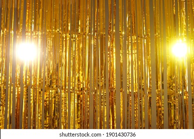 Metallic tinsel background. Bright gold foil fringe curtains hung as interior decor or photo backdrop at a party. Sparkling mylar decoration for festive events. Shiny golden streamers hanging off door - Shutterstock ID 1901430736
