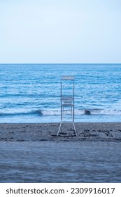 A metallic tower or chair or lifeguard post in the sand of the beach in the Mediterranean sea.