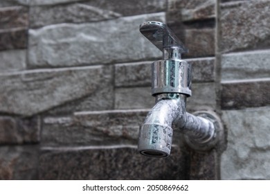 metallic water faucet on a natural stone ceramic wall