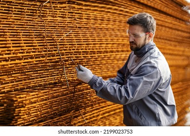 A Metallurgy Worker Binds A Pile Of Steel Armature And Checks On Them.