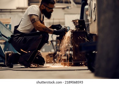 A Metallurgy Worker Using Grinder To Process Metal Parts In Facility.