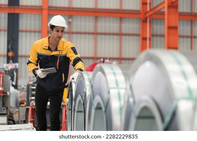 Metalwork manufacturing, warehouse of raw materials. Male factory worker inspecting quality rolls of metal sheet in factory during manufacturing process, wearing safety uniform, use digital tablet - Shutterstock ID 2282229835