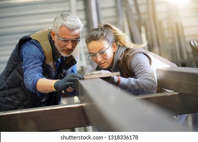 Metalworker With Apprentice In Workshop