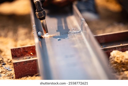 Metalworker wields torch with caution cutting through steel. Sparks fly as craftsman demonstrates safety protocols in industrial setting. Skilled laborer. Dangers of metalworking with protective gear. - Powered by Shutterstock