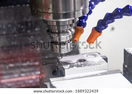 Metalworking CNC lathe milling machine with coolant. Milling  apiece of aluminium. Industrial metalworking cutting process on cnc machine.