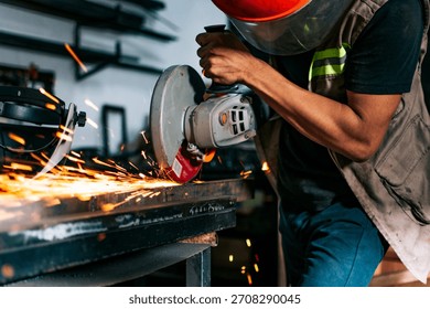Metalworking professional using an angle grinder in the workshop. Man using a grinder in a workshop