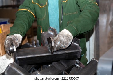 Metalworking. A Worker In Uniform And Protective Gloves Installs Inserts Into A Metal Billet. The Stage Of Production Of Agricultural Machinery.