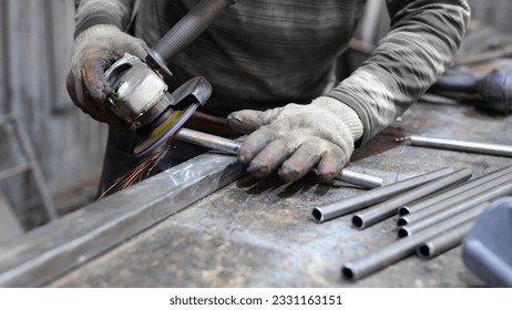 Metalworking workshop. The master grinds the metal with a grinding machine. Sparks