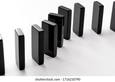 Metaphor For Chain Reaction And Ripple Effect Concept With Domino Tiles Standing In A Row Isolated On White Background