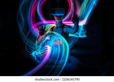 Metaverse digital Avatar, Metaverse Presence, digital technology, cyber world, virtual reality, futuristic lifestyle. Woman in VR glasses playing AR augmented reality NFT game with neon blur lines - Shutterstock ID 2106145790