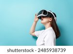 Metaverse technology concept. Woman with VR virtual reality goggles on light blue wall background. Futuristic lifestyle.