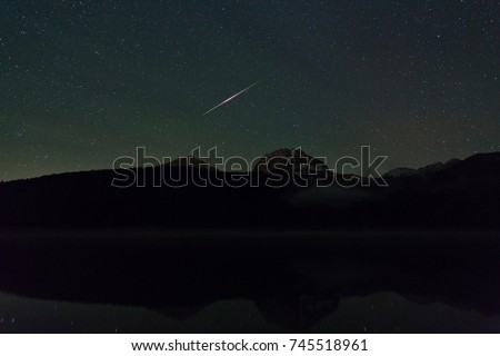 meteor in the night sky over a Black lake in the Durmitor National Park