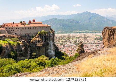 Meteora, Greece - June 16, 2013: Panoramic view on scenic Meteora landscape rock formations with Saint Stephen Nunnery Monastery on the cliff and Kalabaka town just above the mountain