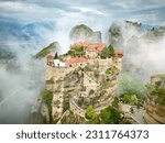 Meteora Varlaam Monastery rising out of the mist. Amazing mystical landscape.  A UNESCO heritage site. Meteora mountains, Thessaly, Greece.