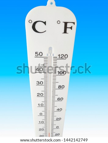 Meterological measuring device reads cold weather on the thermometer with blue background .