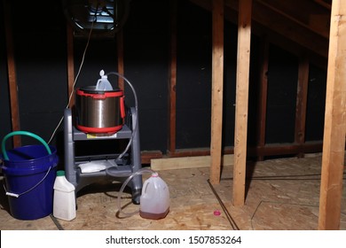 Meth Lab Constructed Of Plastic Bottles, Hoses, And A Pressure Cooker In An Attic With A Fan For Ventilation