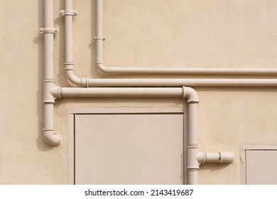 Methane Gas And Water Metal Pipe Against A Plaster Wall Of A Residential Building