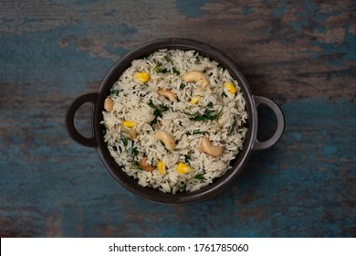 Methi Corn Pulao / Fenugreek Corn Rice Pilaf with Cashews And Vegetables In A Bowl With Wooden Background, Top Angle