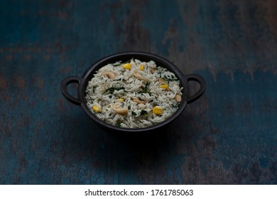 Methi Corn Pulao / Fenugreek Corn Rice Pilaf with Cashews And Vegetables In A Bowl With Wooden Background, Side Angle