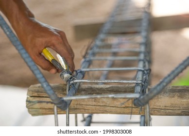 method of tying reinforcing steel bars, tightening wire on rebar using a pincers for formwork construction, selective focus at wire and head of a pincers.                                            