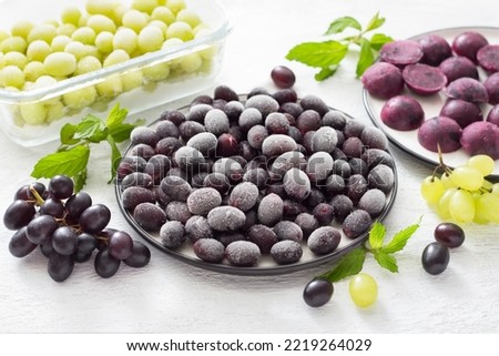 Methods for freezing grapes: bulk frozen, frozen with sugar and frozen puree on a light gray background. Healthy homemade preparations