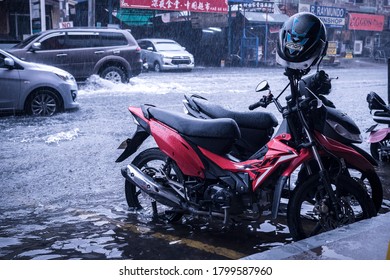 Metro Manila, Philippines - Aug 2020: A Parked Motorbike Near The Street Is Partially Submerged In Flood Waters During A Sudden Storm In The City.