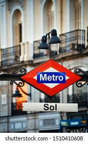 Metro sign of Sol station with business district buildings in street in Madrid, Spain.