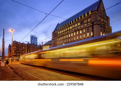 Metro tram passing in front of the new extension of the Manchester town hall, Manchester, England.