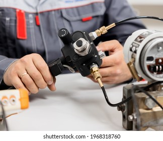 The metrology and standardization laboratory specialist connects the device under test pressure gauge to the pressure calibration and verification instrument. Checking international quality standards - Shutterstock ID 1968318760