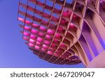 The "Metropol Parasol" also known as "Las Setas" illuminated by pink lighting during the evening blue hour in Seville, Spain