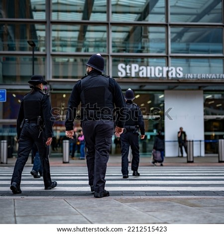 Metropolitan Police Officers patrol in central London, shot from behind as they walk past Oxford circus, Soho and Kings Cross St Pancras