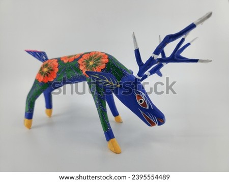 Mexican Alebrije folk art are wooden figures that are crafted by hand and hand painted in the state of Oaxaca in Mexico. This example is a colorful deer on an isolated white background.