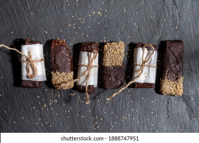 
Mexican amaranth sweets and a peanut bar in chocolate on a wooden table. Sugarless. Vegan desserts