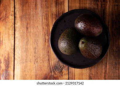 Mexican Avocado (persea Americana) On Rustic Wooden Table. Main Ingredient To Prepare Guacamole. Top View Image With Copy Space.