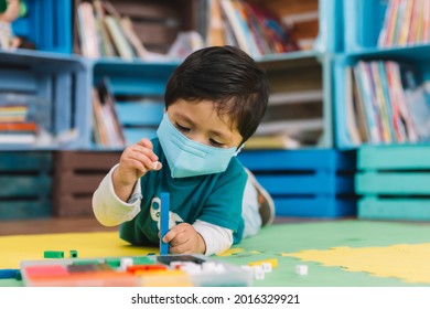 Mexican Baby In School With Face Mask Playing Small Colorful Pieces