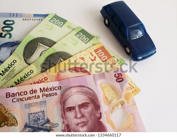 mexican\
banknotes and figure of a car in dark\
blue